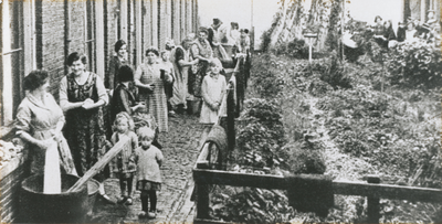 875071 Afbeelding van een groep vrouwen op straat aan de was, op de Oranjehof in Wijk C te Utrecht.